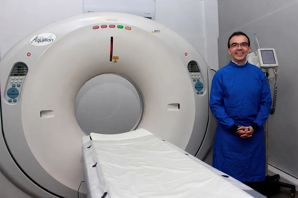 Dr. Fernando Cadena junto al tomógrafo CADLEV